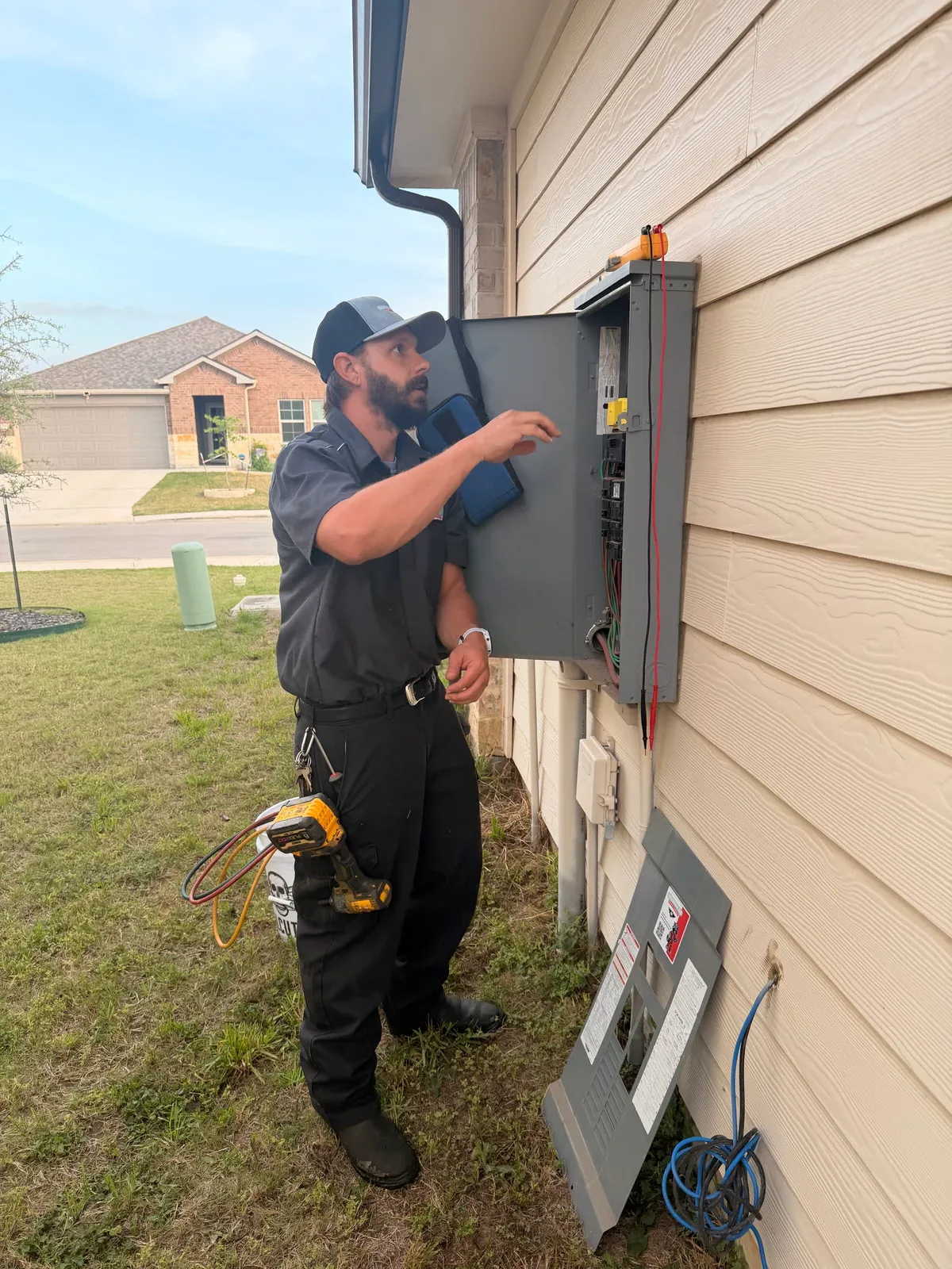 A Moorhead technician checking an open electrical panel at a Texas home.