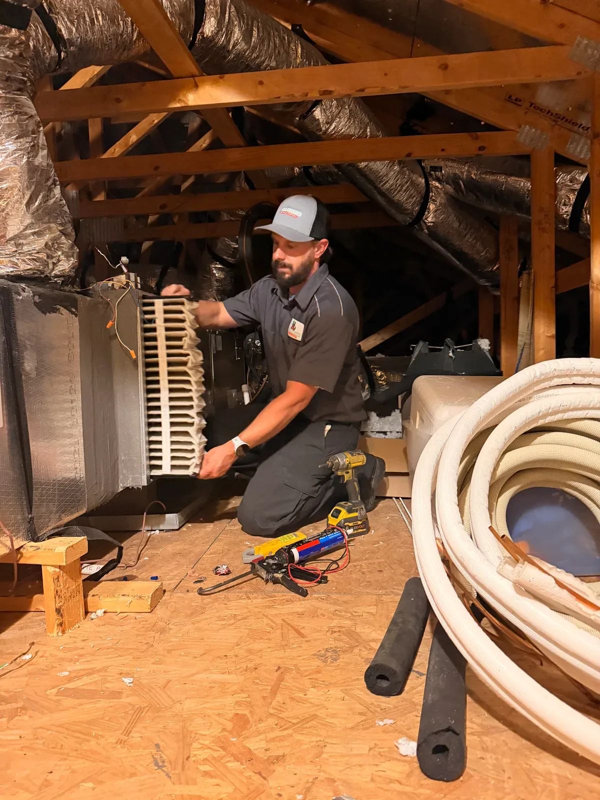 A Moorhead technician replacing a dirty air filter at an attic air handler.