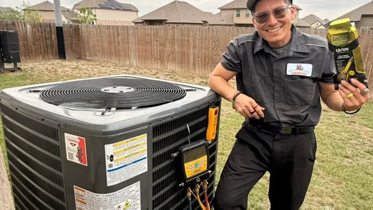 A Moorhead technician checking an AC system's refrigerant charge with manifold gauges — low refrigerant is a leading cause of a frozen coil.