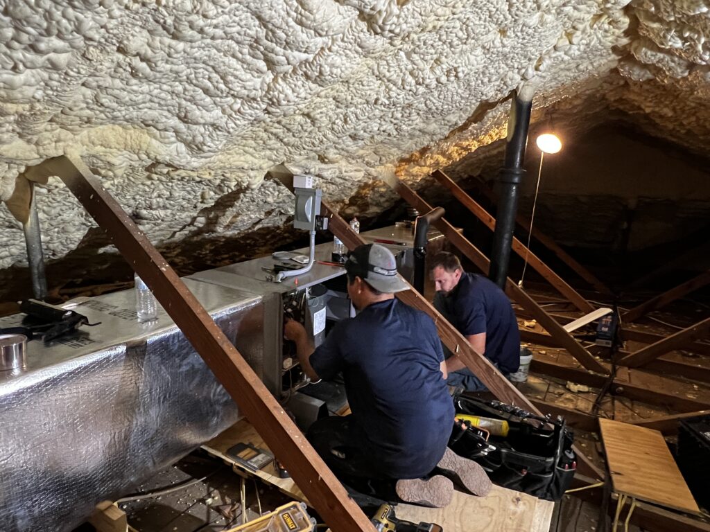 Moorhead Service Company technician professionally installing a brand new, high-efficiency furnace in a client's home in Seguin or San Antonio.